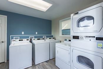 A row of washes and dryers in a laundry room